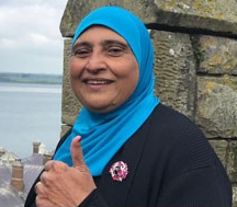 Photo of Rabia smiling and doing a thumbs up pose