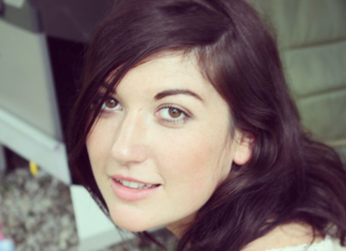 female with log dark hair with a gentle smile