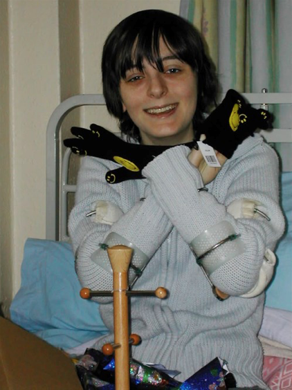 female holding soft toy and in a hospital bed