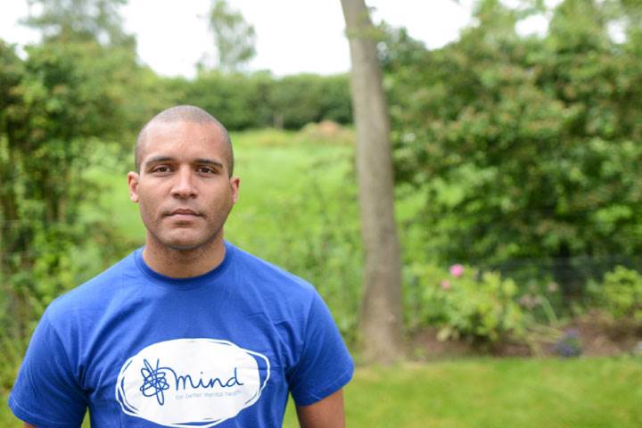 Clarke Carlisle standing outside in green space looking at camera 