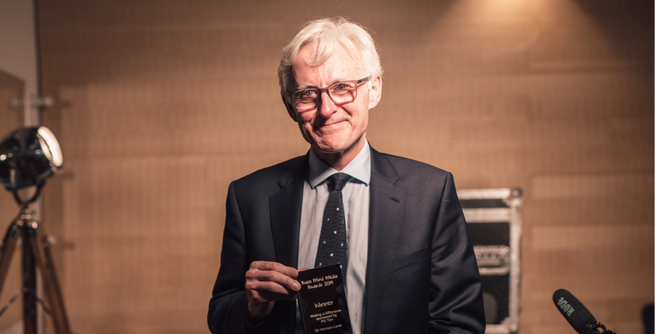 male wearing a suit, holding an award for Bupa Mind Media Awards 2019