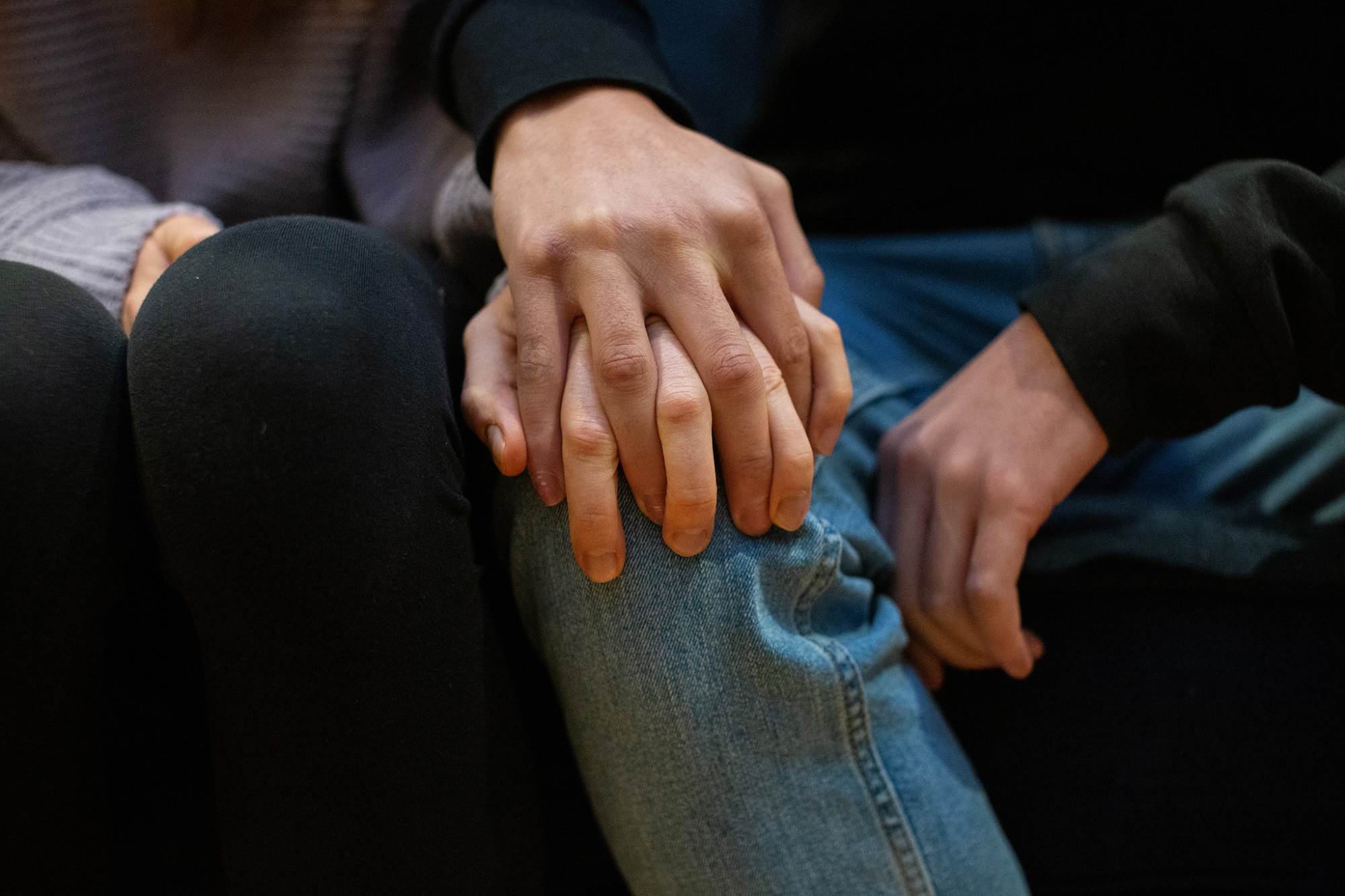Close Up Of People Sat Clutching Hands