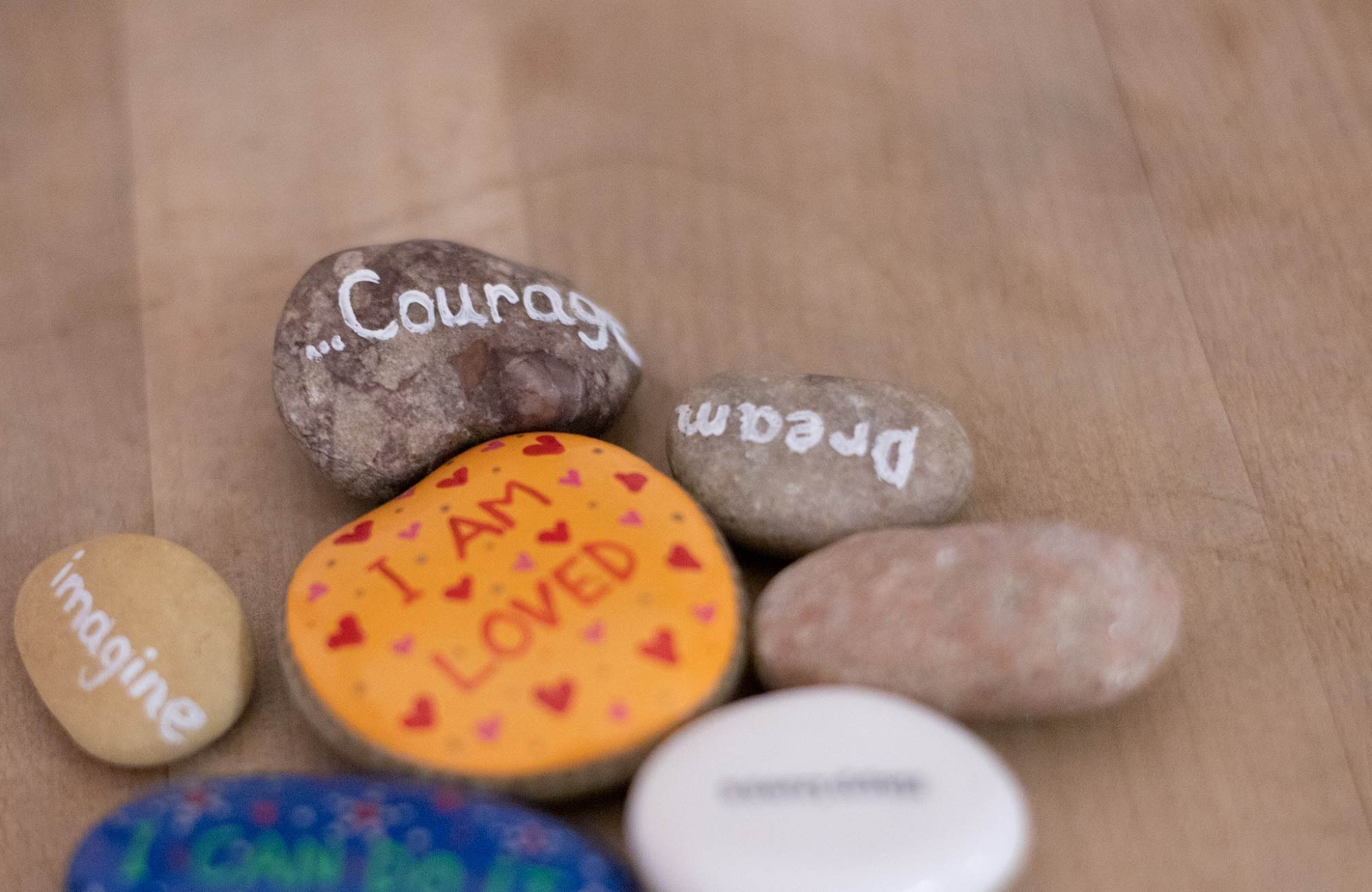 Close Up Of Stones Painted With Supportive Messages