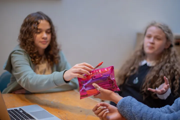 Girls Sharing Pens Out Of Pencil Case Sat At Desk Girls Sharing Pens Out Of Pencil Case Sat At Desk