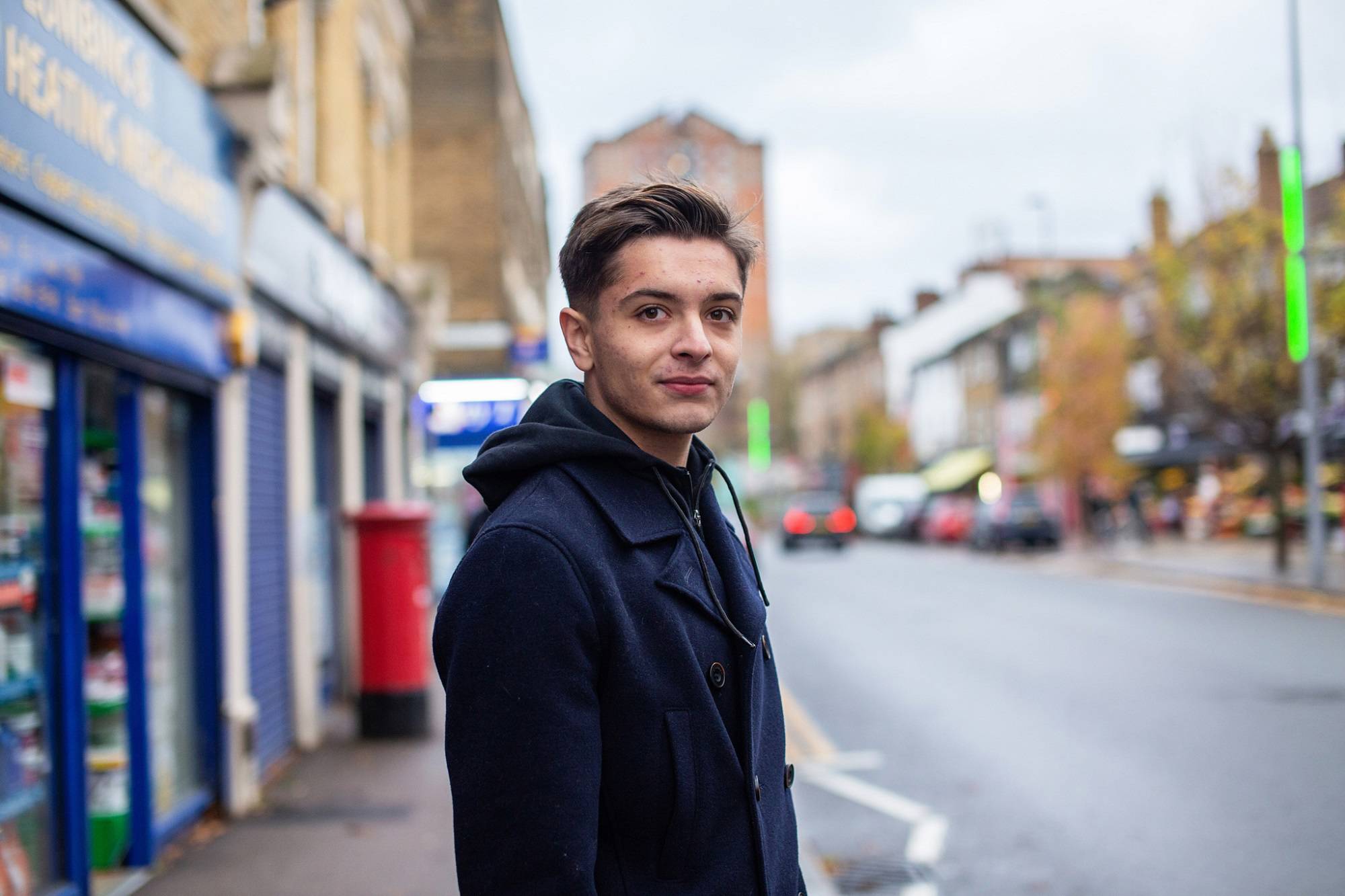 Teen Boy Looks At Camera While In Town Centre