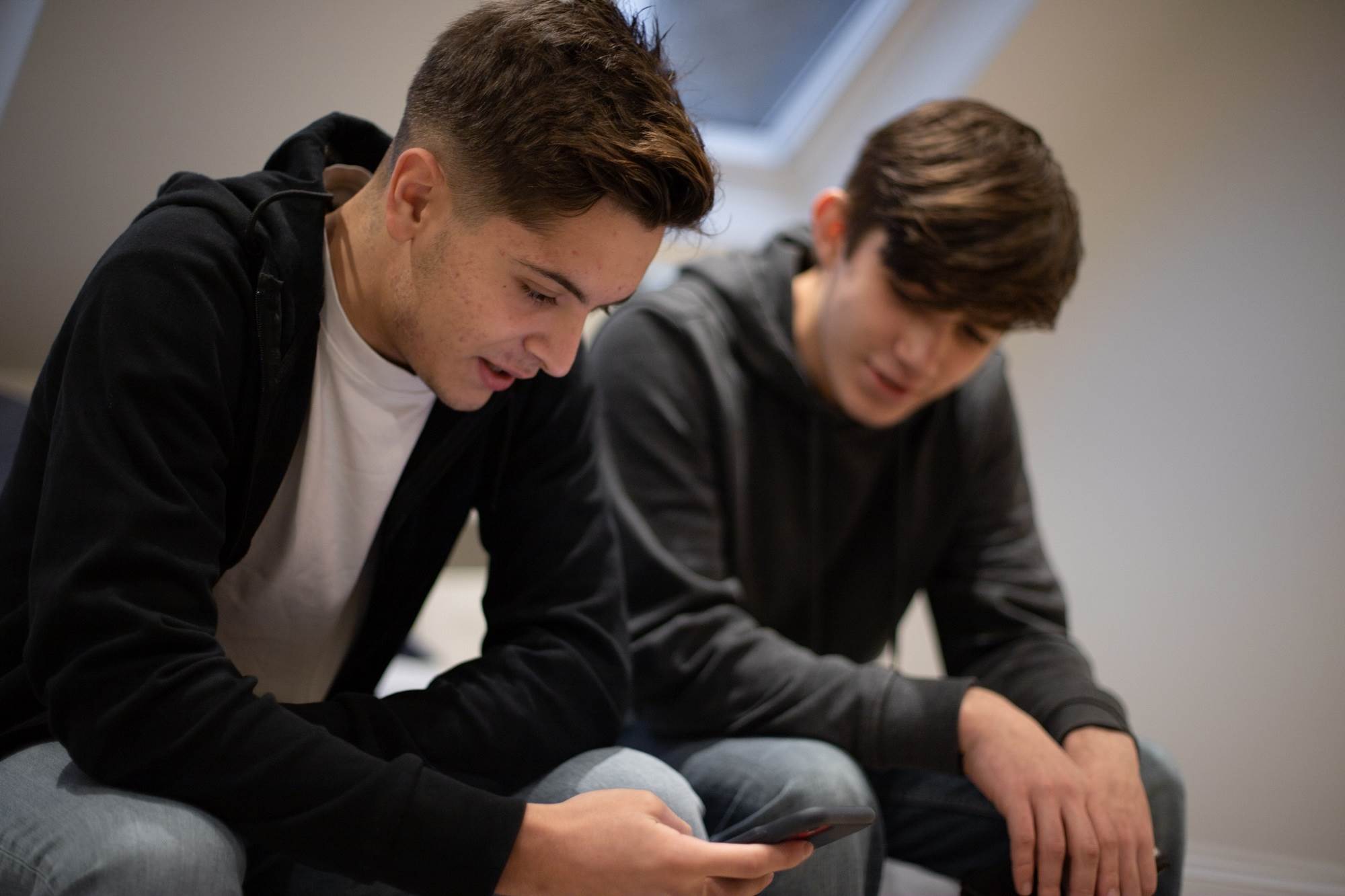 Teen Boys Discussing Mobile Content Sat Down