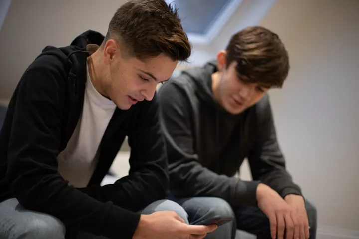 Teen Boys Discussing Mobile Content Sat Down Teen Boys Discussing Mobile Content Sat Down