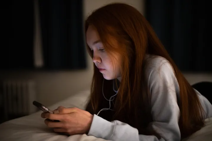 Teen Girl Looking At Phone With Neutral Expression Teen Girl Looking At Phone With Neutral Expression