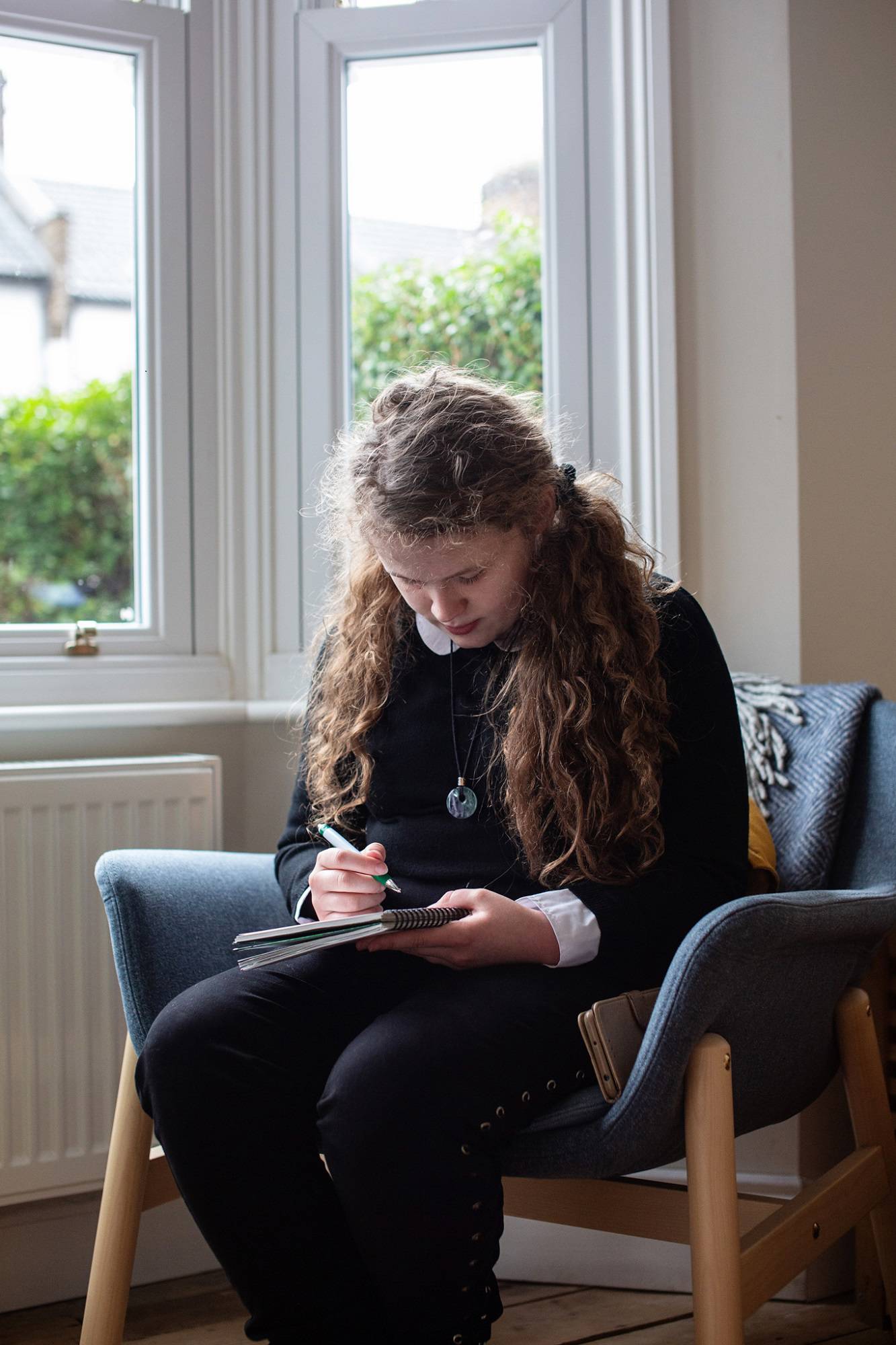 Teen Girl Sits Writing Close Up