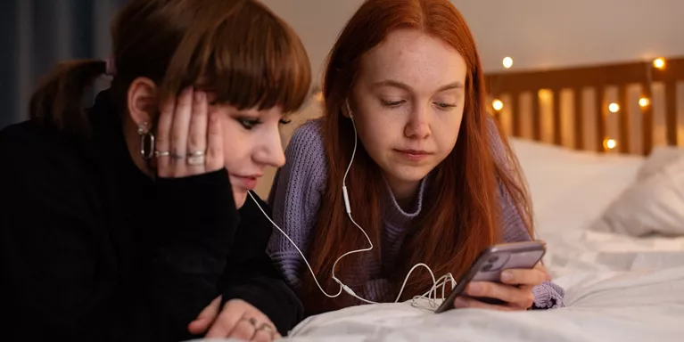 Teen Girls Sharing Music On Phone Neutral Expression