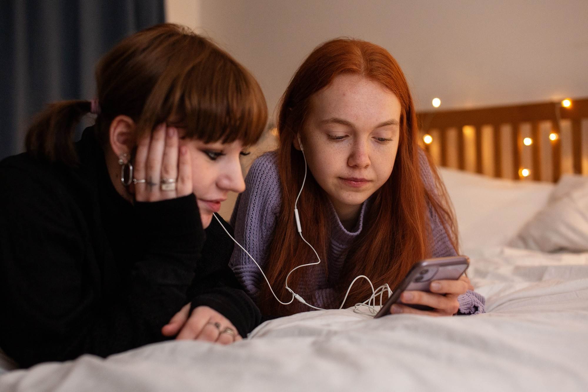 Teen Girls Sharing Music On Phone Neutral Expression