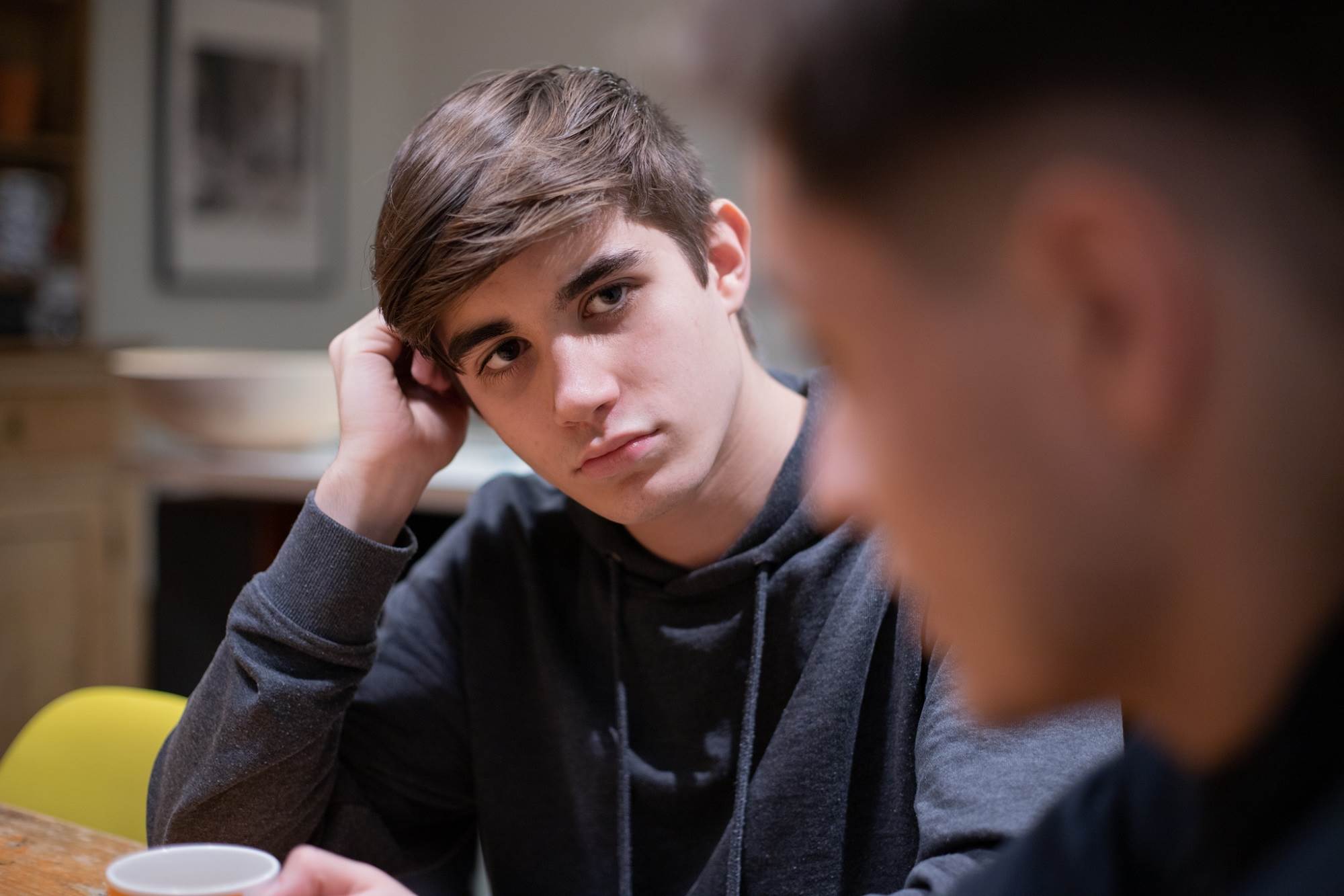 Two Teenage Boys Talking One Looking Serious