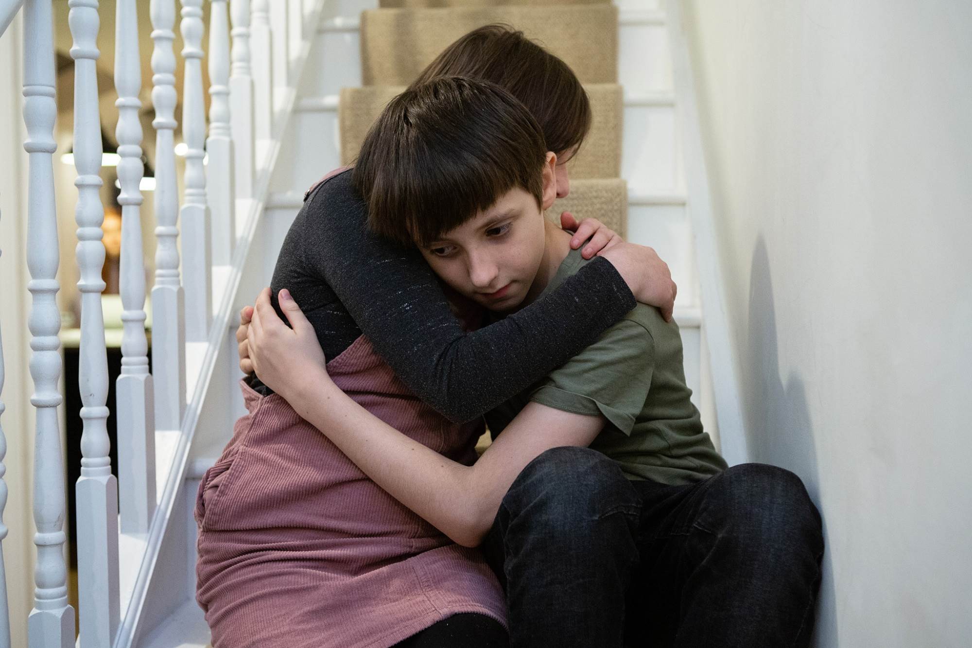 Young Boy Being Hugged On Stairs