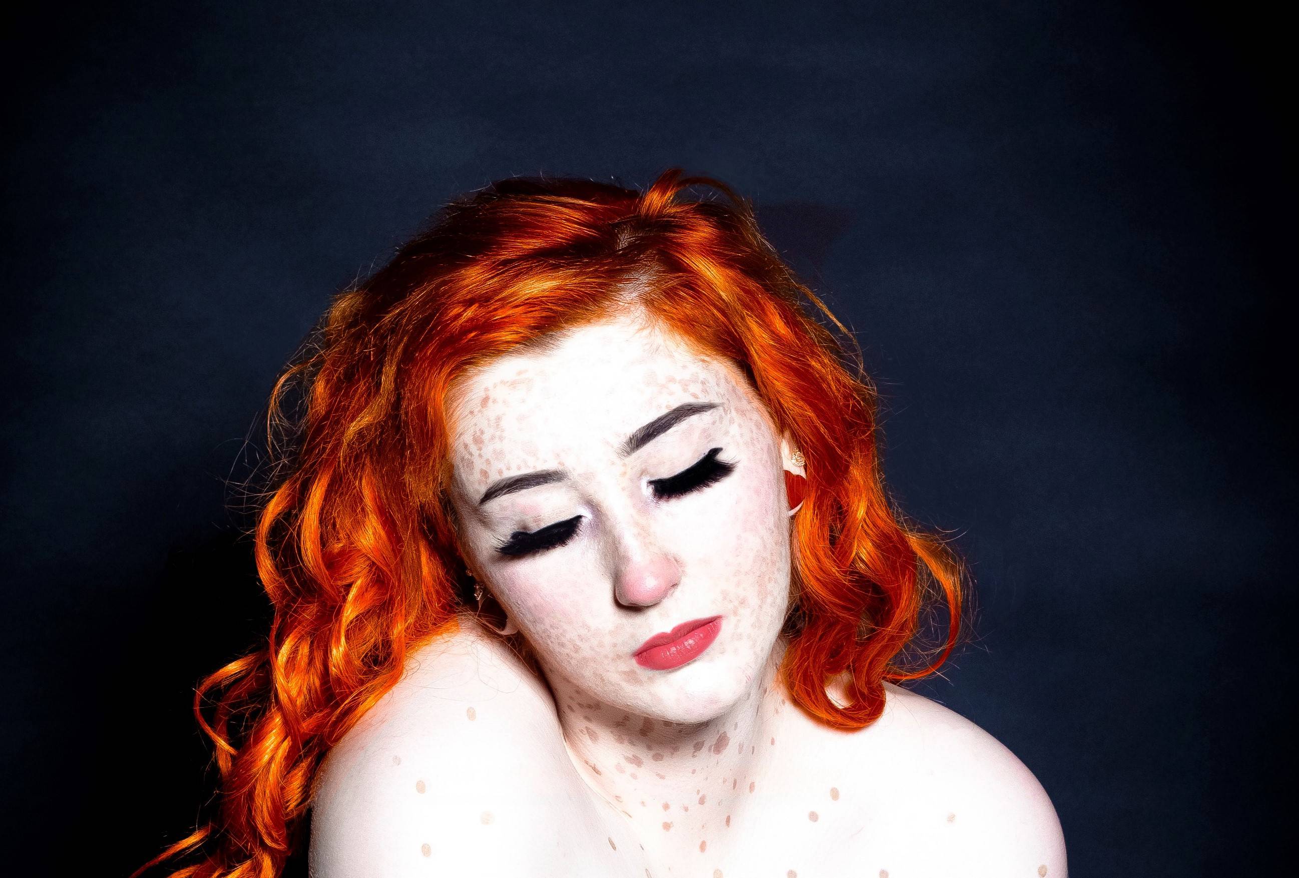 white women with bright red hair looking down so you cannot see her eyes