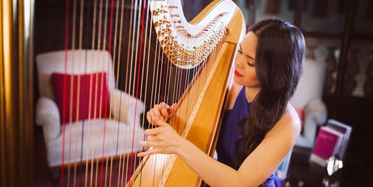 Harpist greeting guests, sponsored by Elan Artists