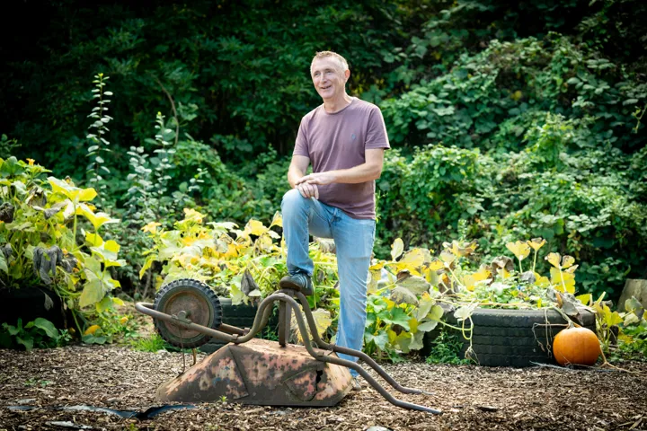 Person standing next to wheelbarrow Person standing next to wheelbarrow