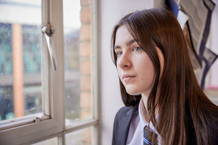 Girl looking through window