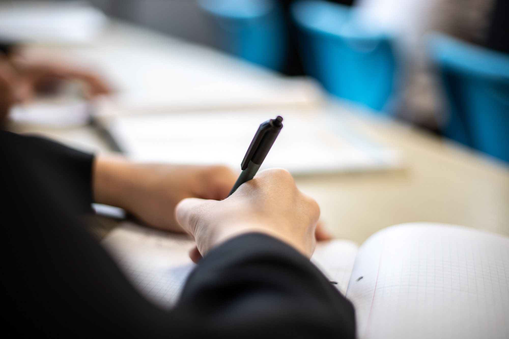 Close Up Young Person In School Writing On Notebook