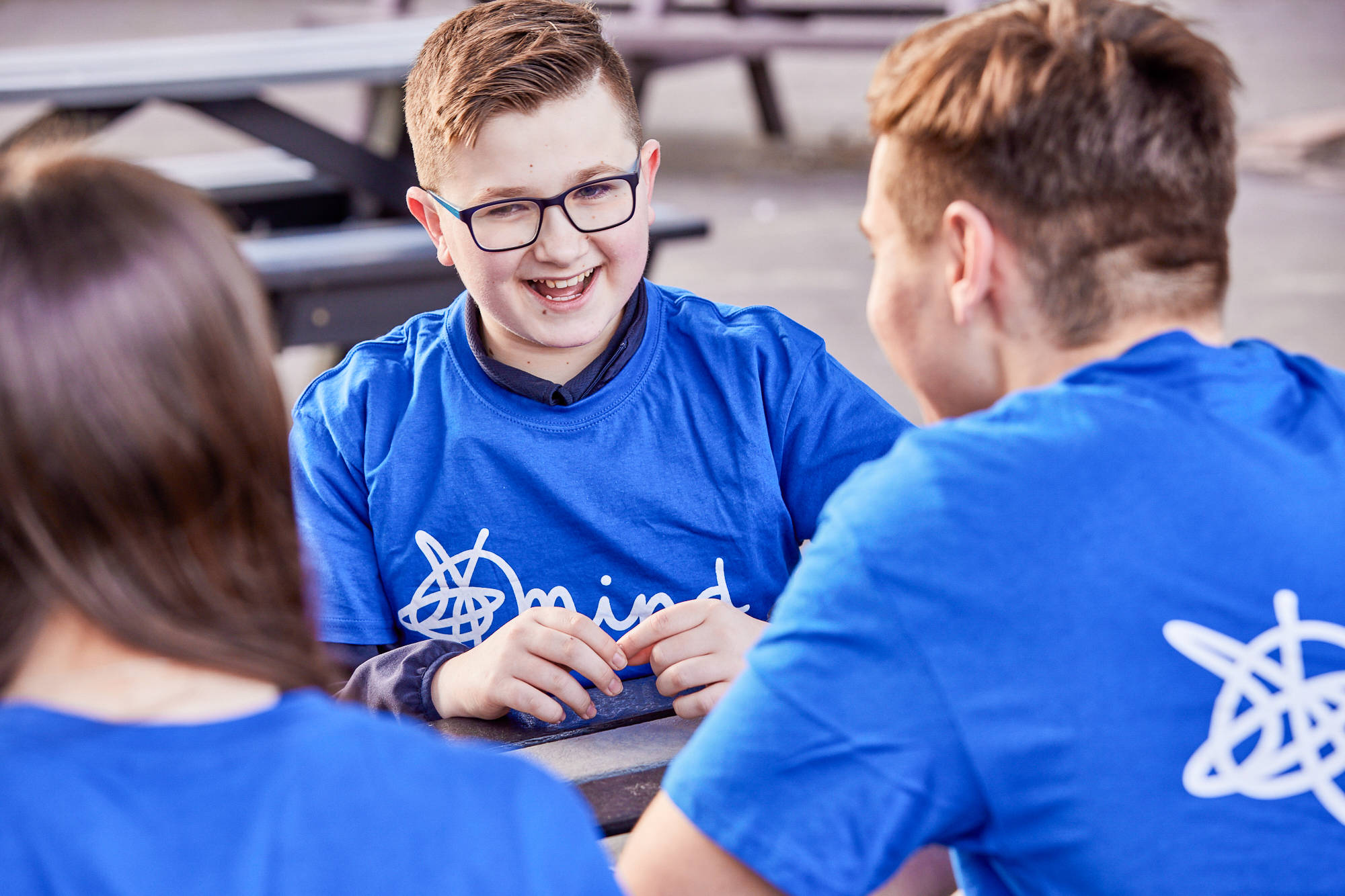 Close Up Of Young Person Laughing In Discussion At A Picnic Table In A Playground