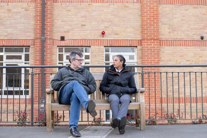 Student And Teacher Chatting On Bench Student And Teacher Chatting On Bench