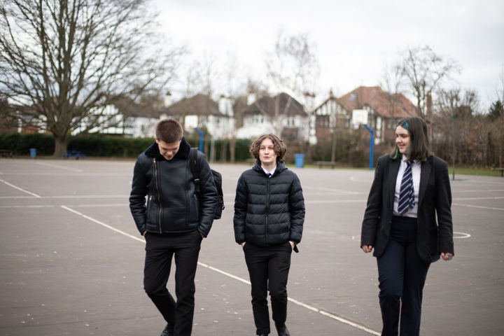 Three Young People Walking Through School