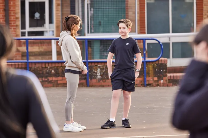 Two Young People Chatting In A Playground Two Young People Chatting In A Playground