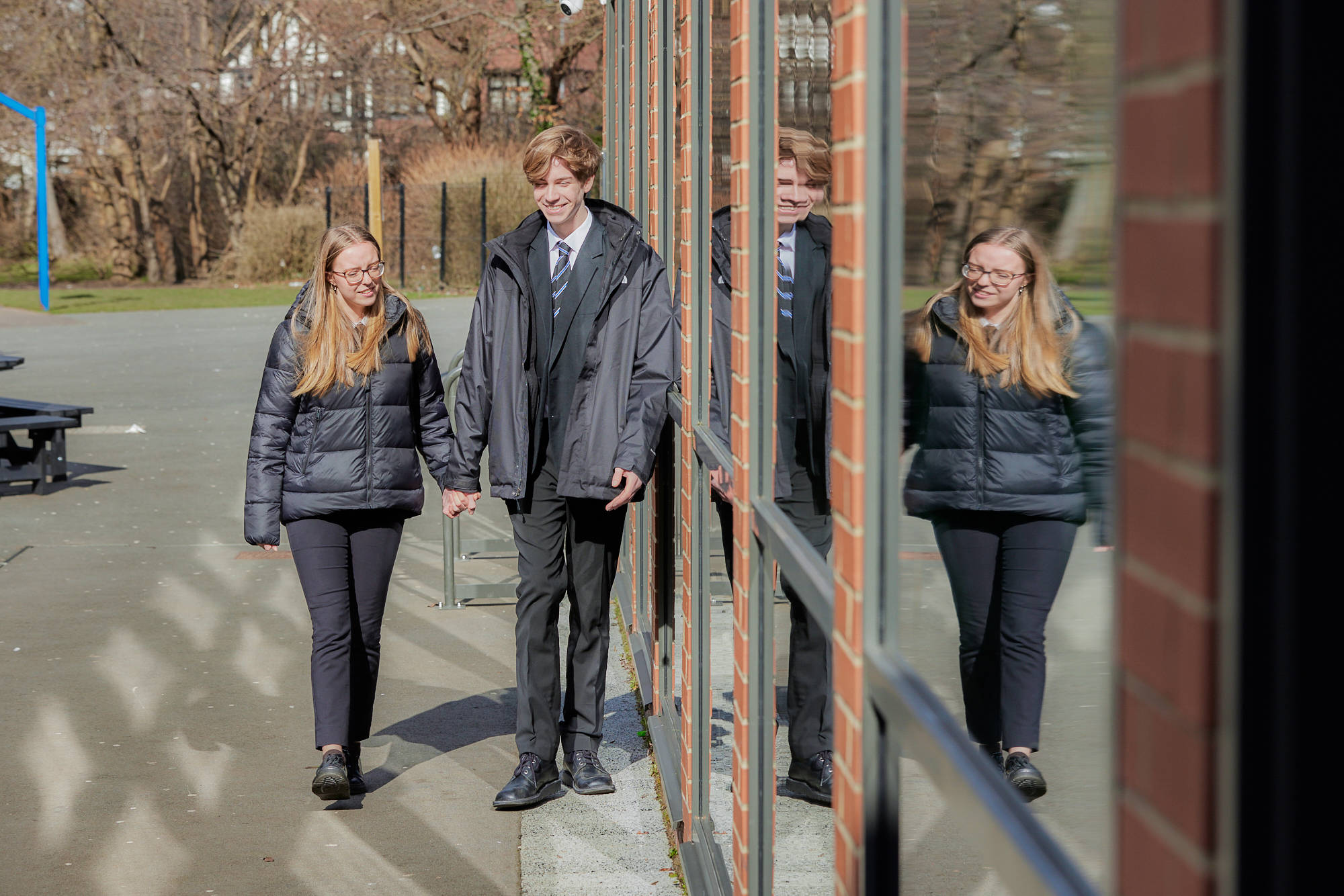 Young People Holding Hands Outside School Walking