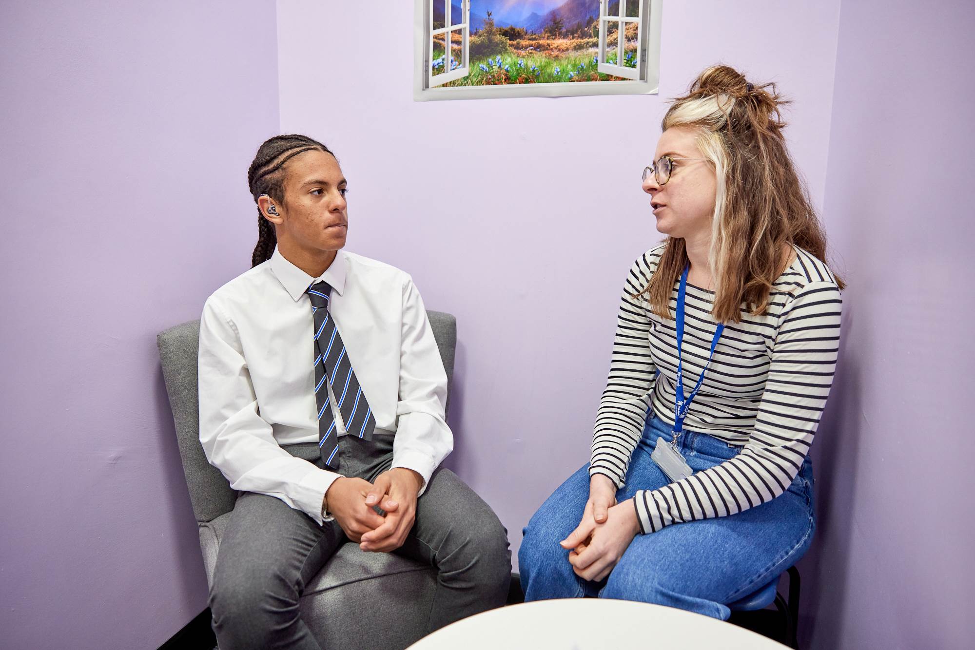Young Person And Teacher Chatting In Room