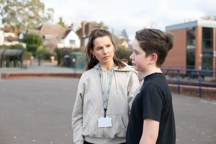 Young Person And Teacher Chatting Outside