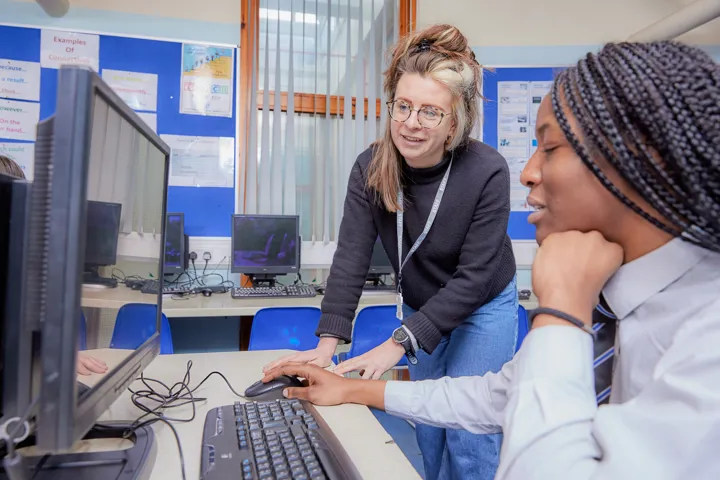 Young Person And Teacher Working On Computer