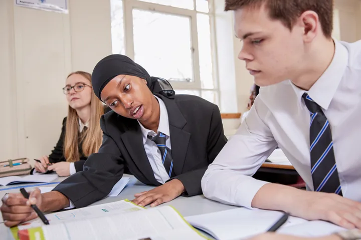 Young Person Helping Someone In Class
