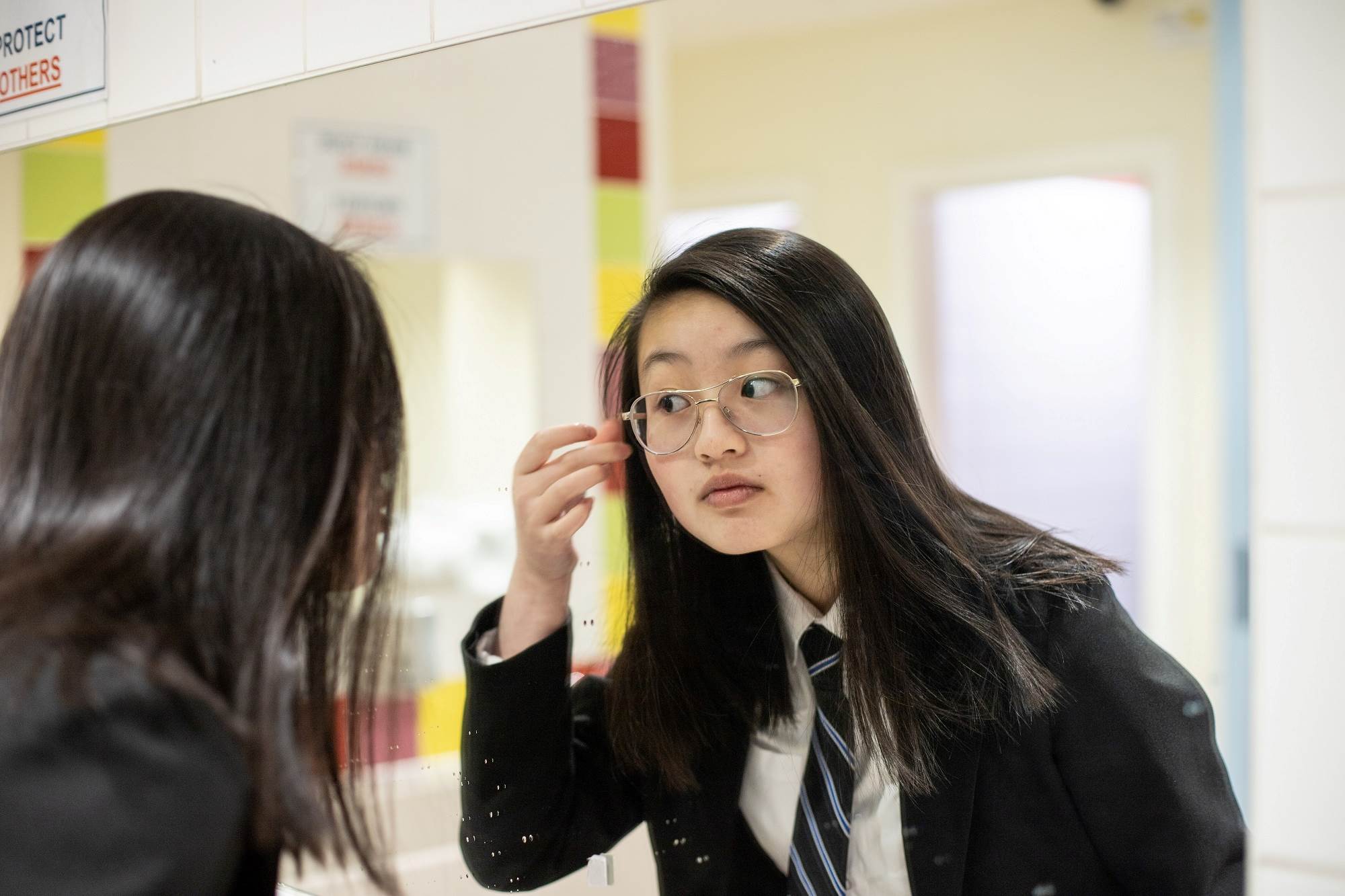 Young Person Looking At Themselves In The Mirror