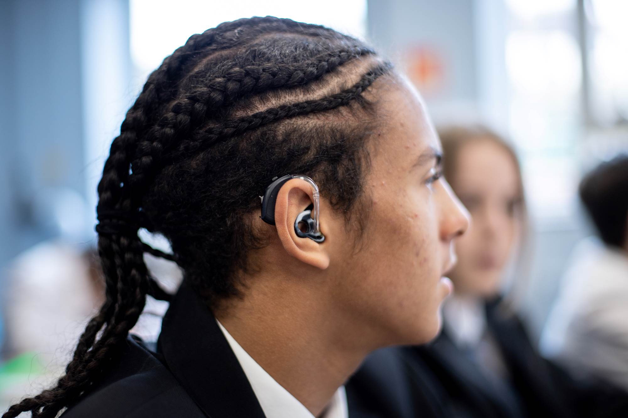 Young Person Looking To The Side With A Hearing Aid