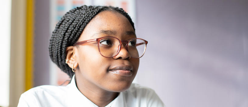 Young Person Smiling In Classroom At The Camera