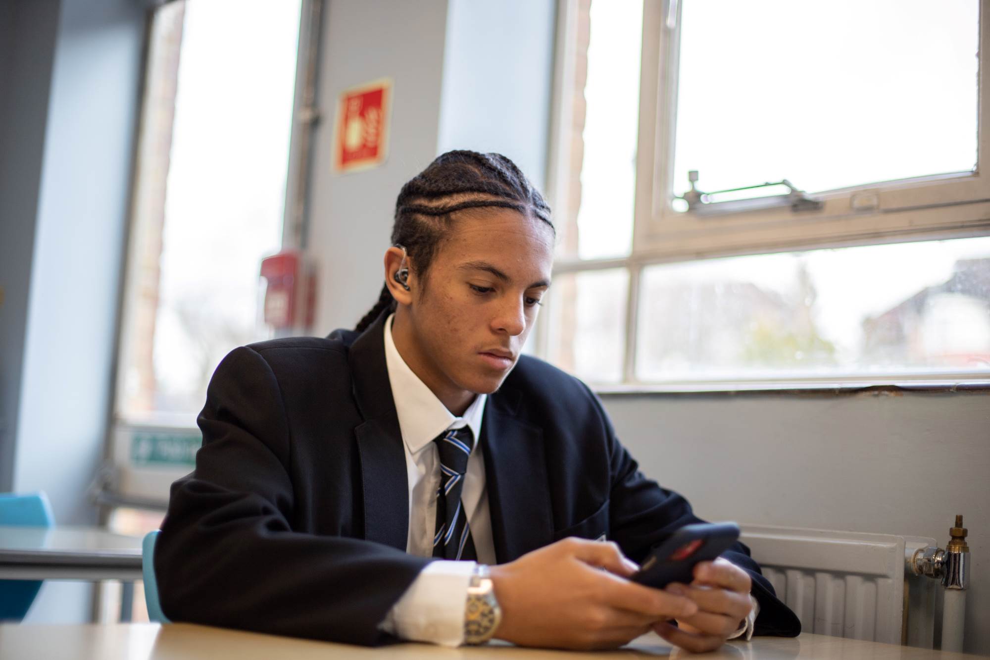 Young Person Texting At Desk