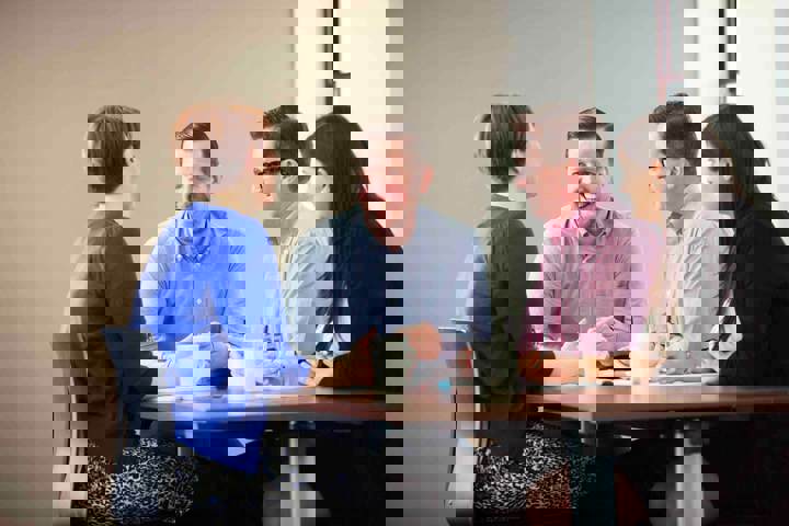 A group of engaged people in a meeting room setting A group of engaged people in a meeting room setting