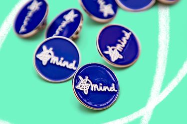 Blue Mind pin badges on green background