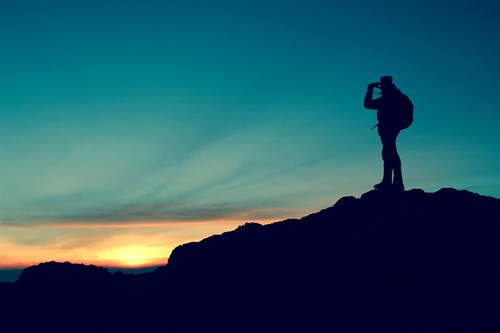 Trekker watching the sun rise from Snowdon mountain