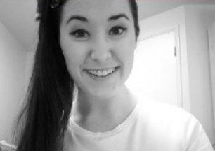 Charlotte smiling with a brightly lit window in the background