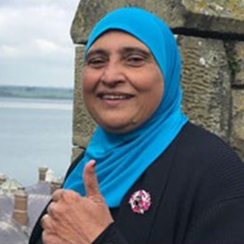 Photo of Rabia smiling and doing a thumbs up pose