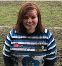 Photo of Laura smiling and standing on a rugby field
