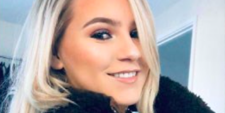 Girl with blonde hair smiling at the camera