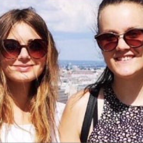 Two teenage girls looking the camera wearing sunglasses on a sunny day