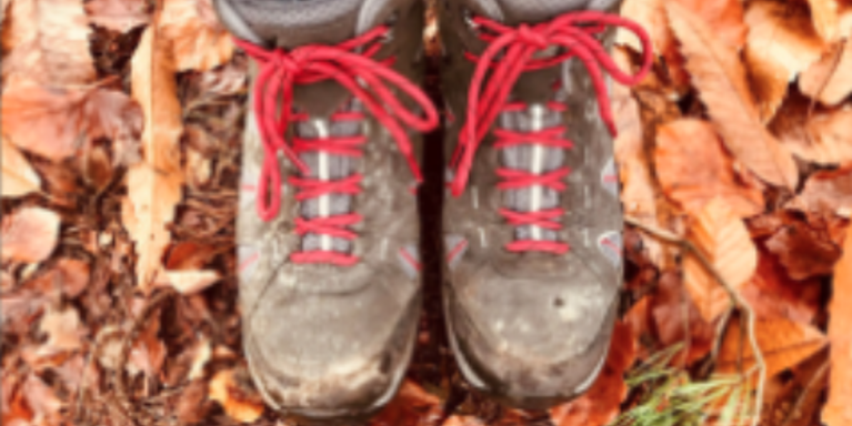 On the autumn leave-covered floor, Nikki's walking boots are worn and laced with bright red laces.