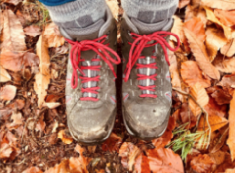 On the autumn leave-covered floor, Nikki's walking boots are worn and laced with bright red laces.