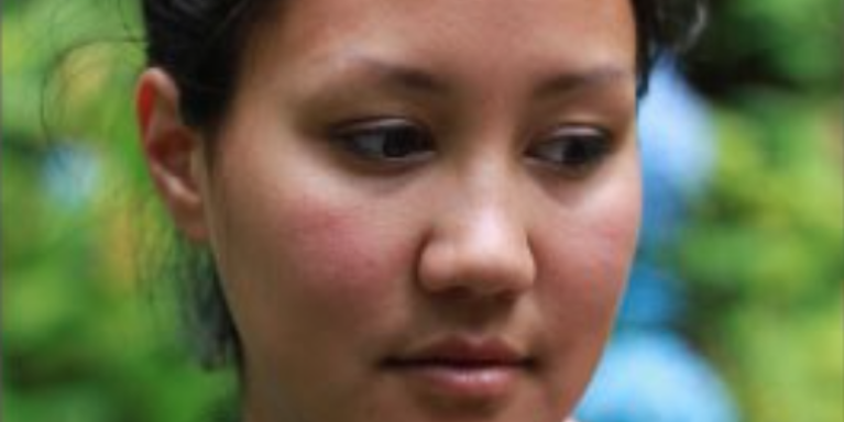 Woman facing the camera looking down and to the right was a content expression
