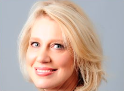 Female with short light blonde hair, smiling 