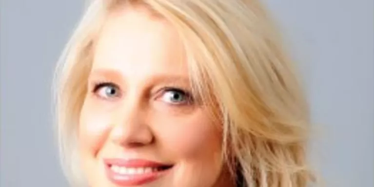 Female with short light blonde hair, smiling 