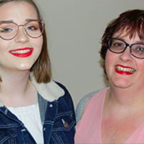 a young and a middle aged female smiling standing next to each other