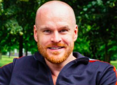 male with bald head and ginger beard smiling 